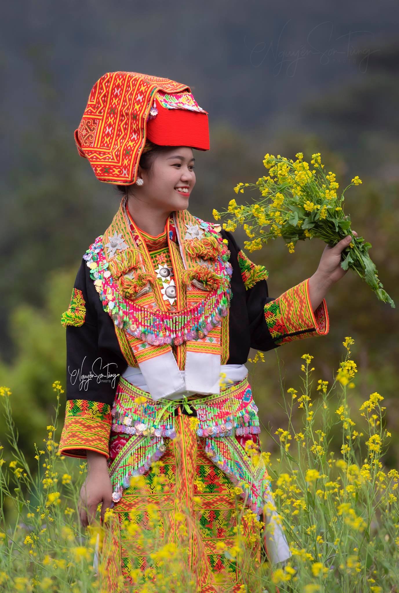 Cô gái giơ cao bó hoa cải vàng
