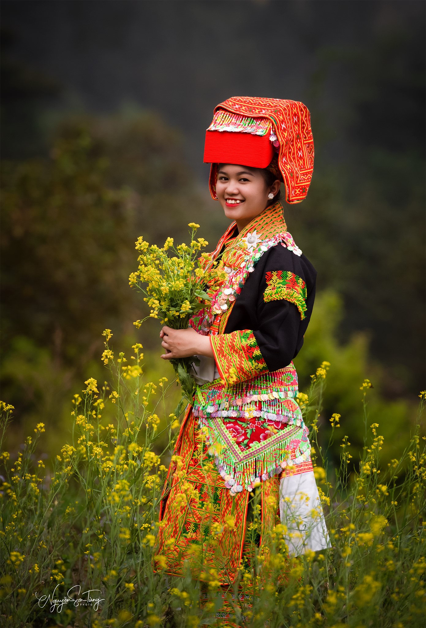 Cô gái ôm hoa cải vàng cười