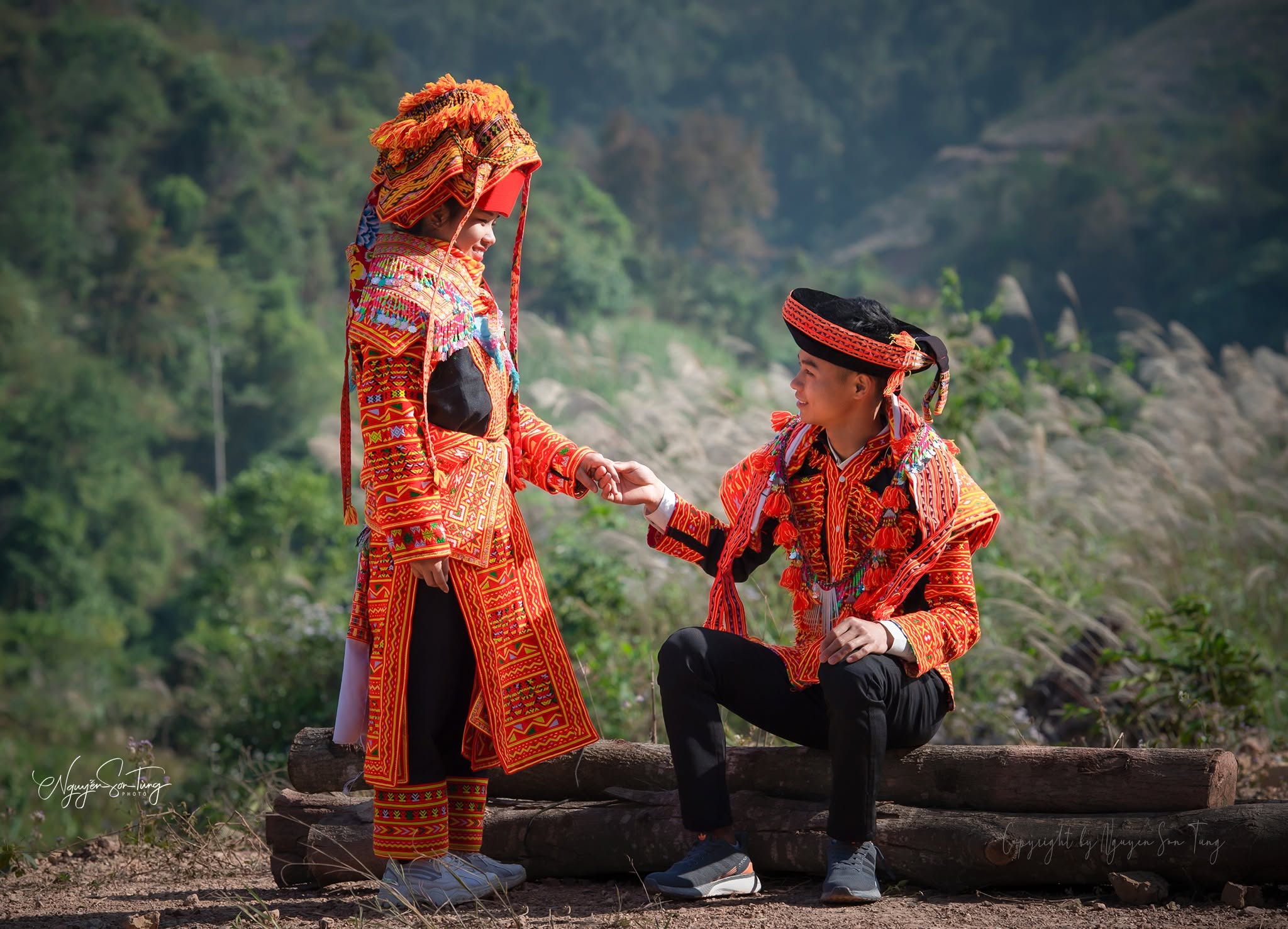 Người phụ nữ đứng cạnh người đàn ông ngồi