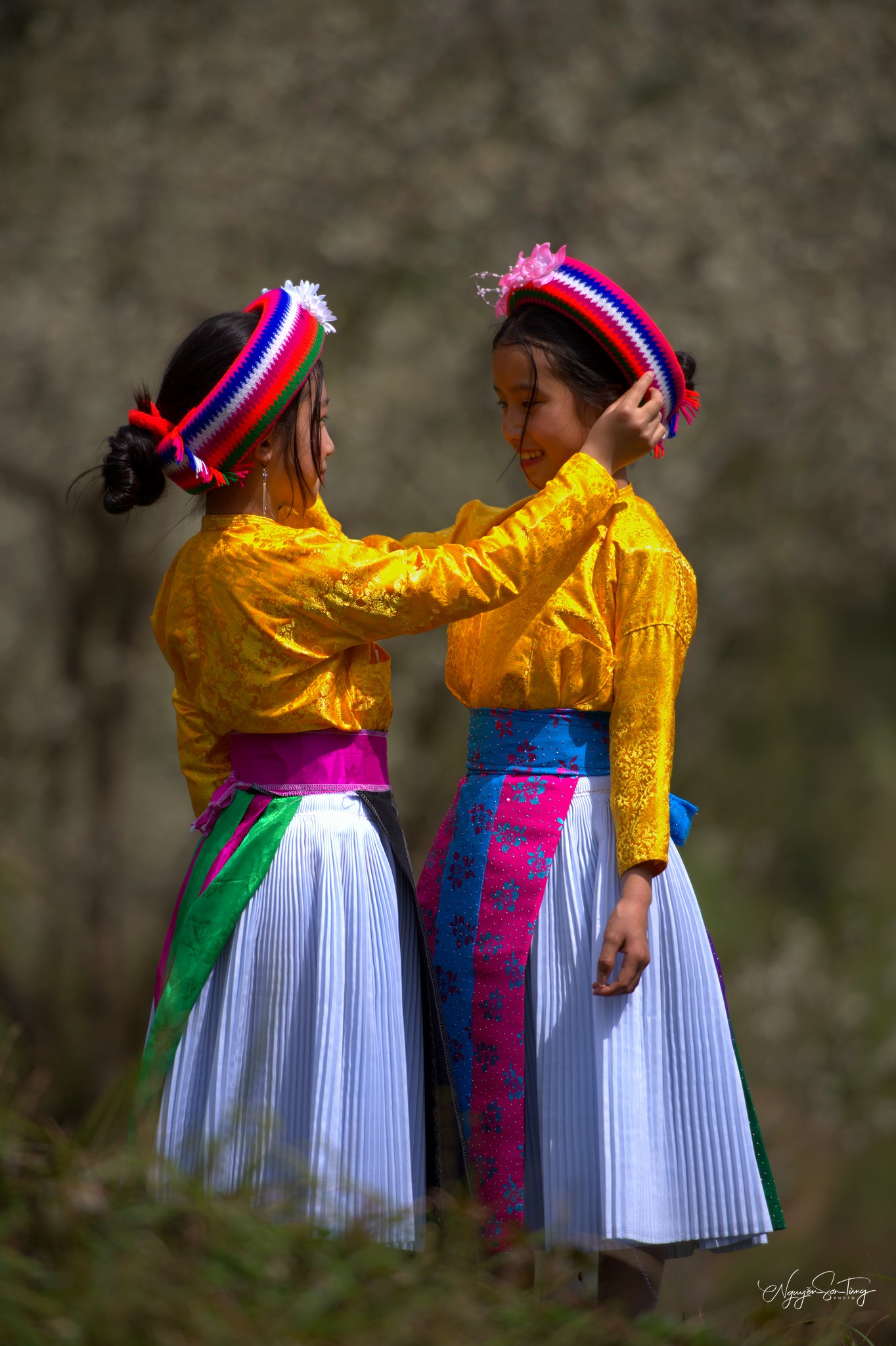 Cô chị chỉnh khăn cho em gái, hai chị em áo vàng rực