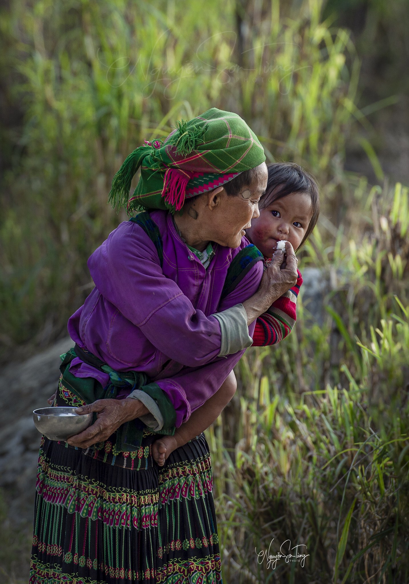 Người bà ôm cháu nhỏ ngoài trời