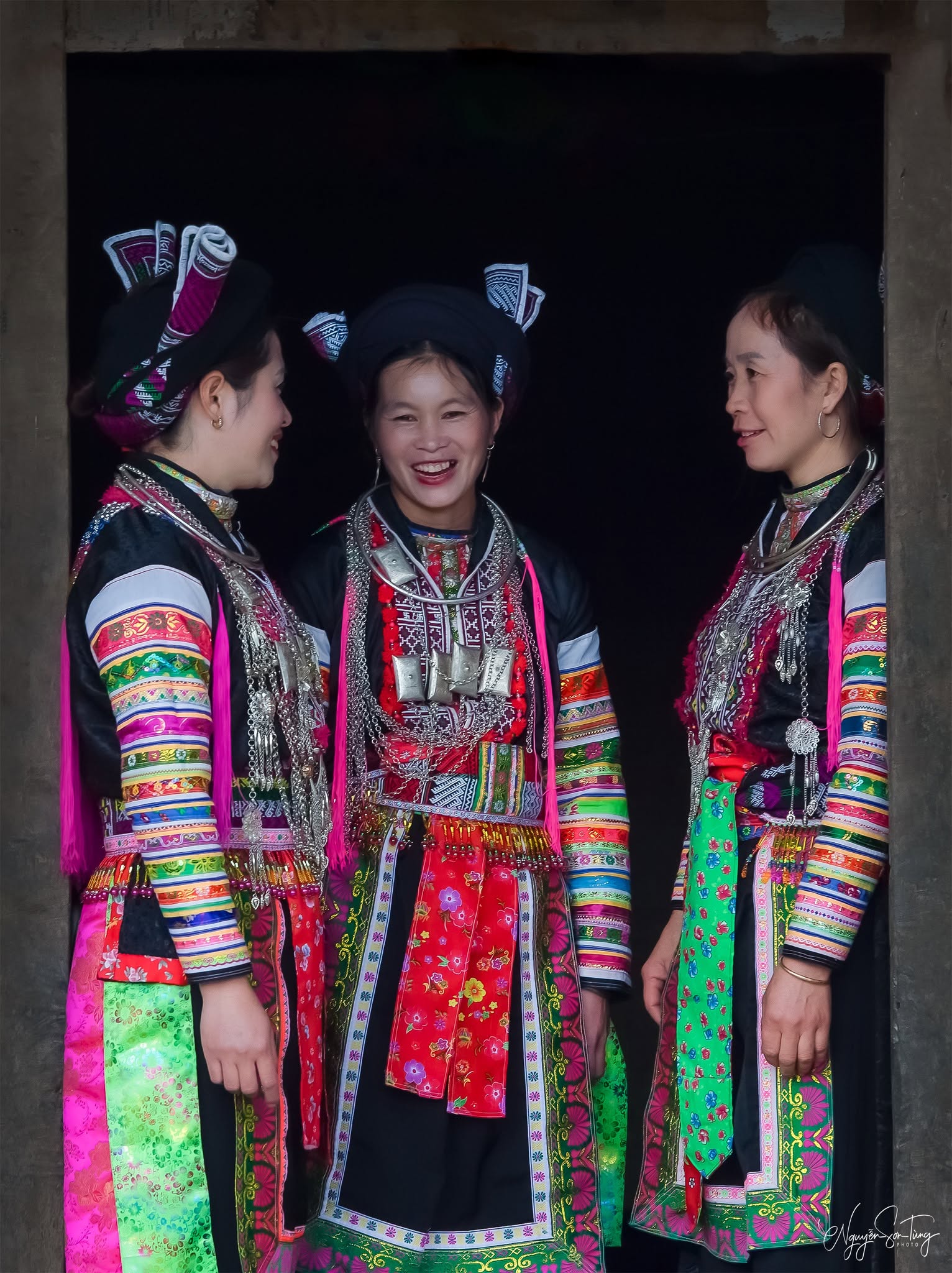 Ba phụ nữ Dao đỏ trò chuyện trong khung cửa tối